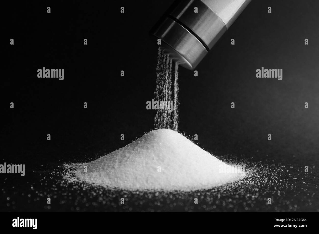 Salz aus dem Schüttler auf schwarzem Hintergrund, Nahaufnahme Stockfoto