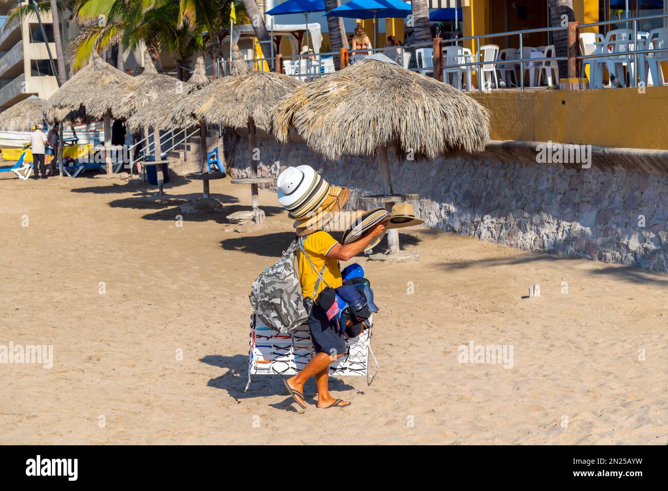 Ein Mexikaner verkauft und trägt Hüte am Sandstrand in der Golden Zone von Mazatlan, Mexiko. Stockfoto