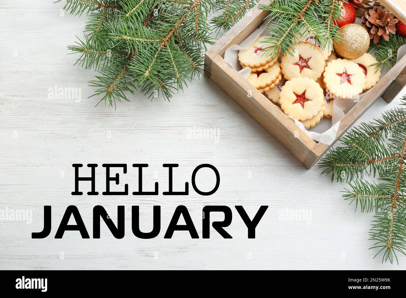 Hallo Januar Grußkarte. Linzer Kekse mit süßer Marmelade und Tannenzweigen auf Holztisch, flach liegend Stockfoto