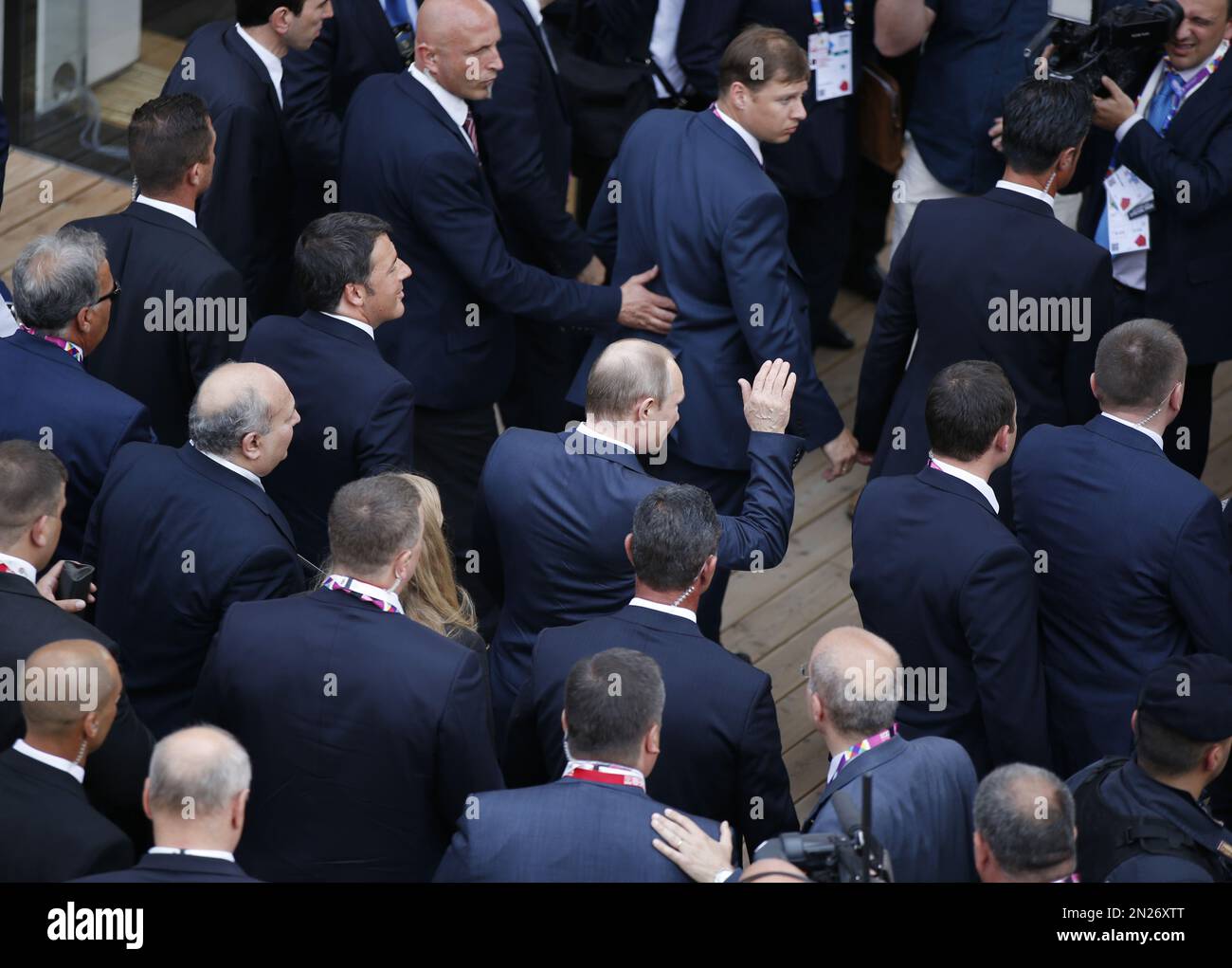 Russian President Vladimir Putin, center, back to the camera, waves as he arrives at the Russian pavilion at the 2015 Expo in Rho, near Milan, Italy, Wednesday, June 10, 2015. Putin was meeting Wednesday with Italian officials and Pope Francis as the U.S. sought to encourage the Vatican to join the West in condemning Moscow's actions in Ukraine. (AP Photo/Luca Bruno) Stockfoto