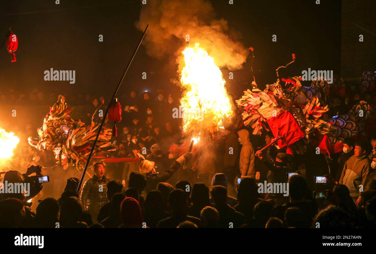 YUNCHENG, CHINA - 6. FEBRUAR 2023 - Dorfbewohner beobachten einen Feuerdrachen in einem Kulturzentrum im Dorf Wudui, Taiyang Township, Jishan Coun Stockfoto