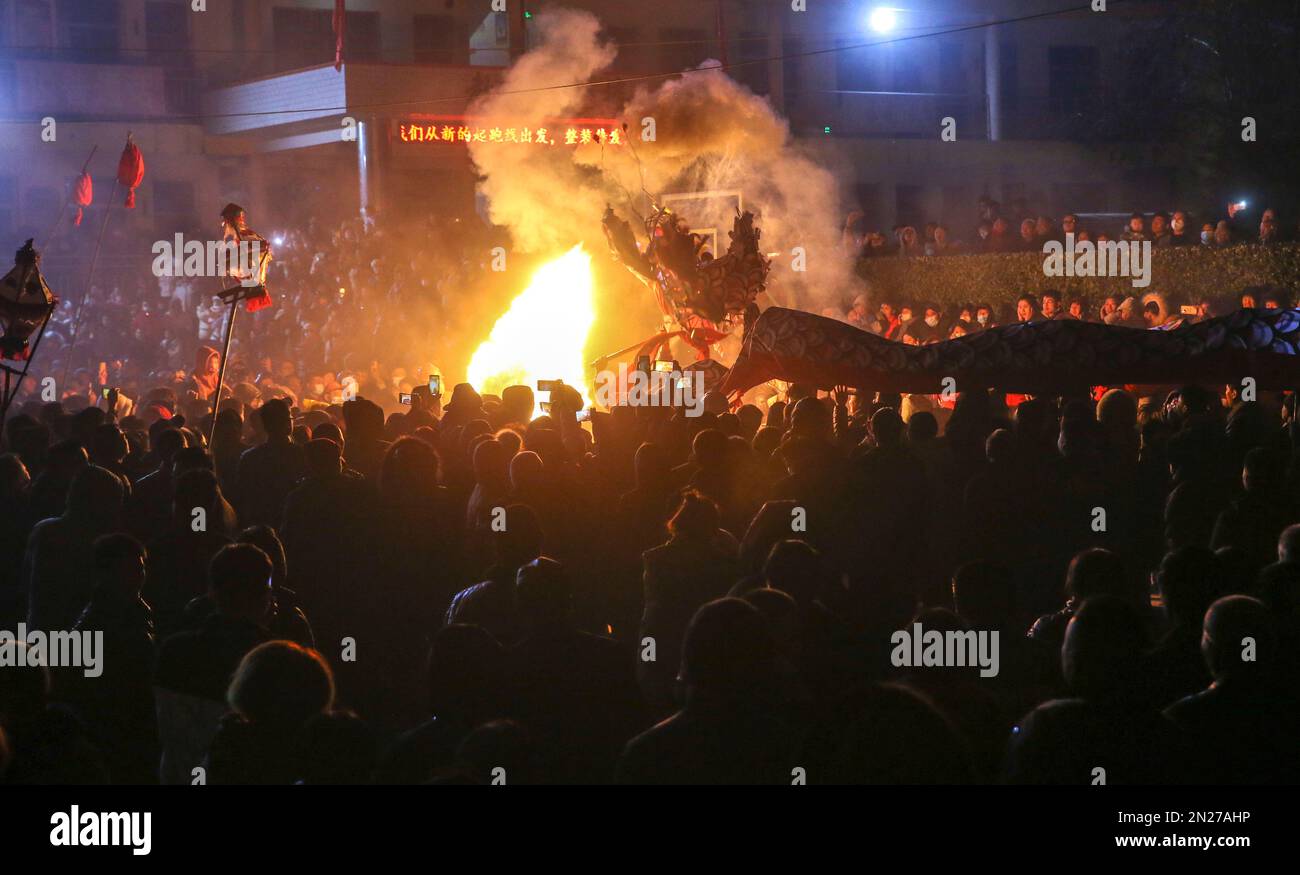 YUNCHENG, CHINA - 6. FEBRUAR 2023 - Dorfbewohner beobachten einen Feuerdrachen in einem Kulturzentrum im Dorf Wudui, Taiyang Township, Jishan Coun Stockfoto