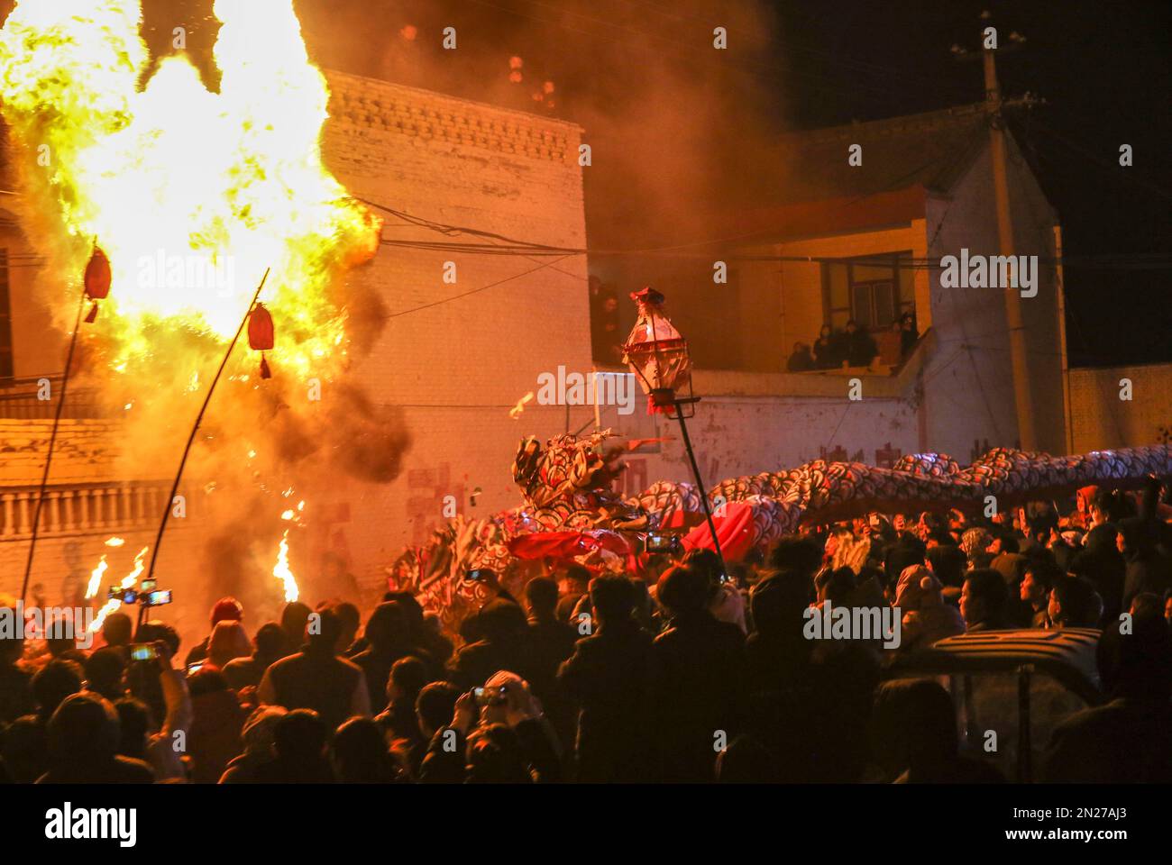 YUNCHENG, CHINA - 6. FEBRUAR 2023 - Dorfbewohner beobachten einen Feuerdrachen in einem Kulturzentrum im Dorf Wudui, Taiyang Township, Jishan Coun Stockfoto