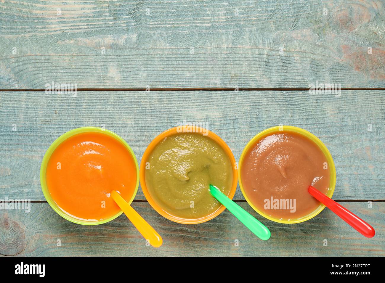 Gesunde Babynahrung auf blauem Holztisch, flach liegend. Platz für Text Stockfoto