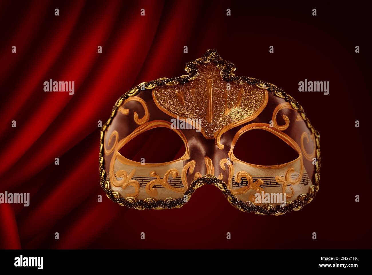 Wunderschöne Karnevalsmaske vor dem roten Vorhang Stockfoto