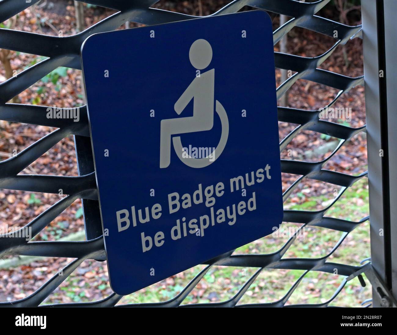 Ein blaues Abzeichen muss angezeigt werden, ein Schild mit dem Symbol „deaktiviert“, das eine separate Parkzone angibt Stockfoto