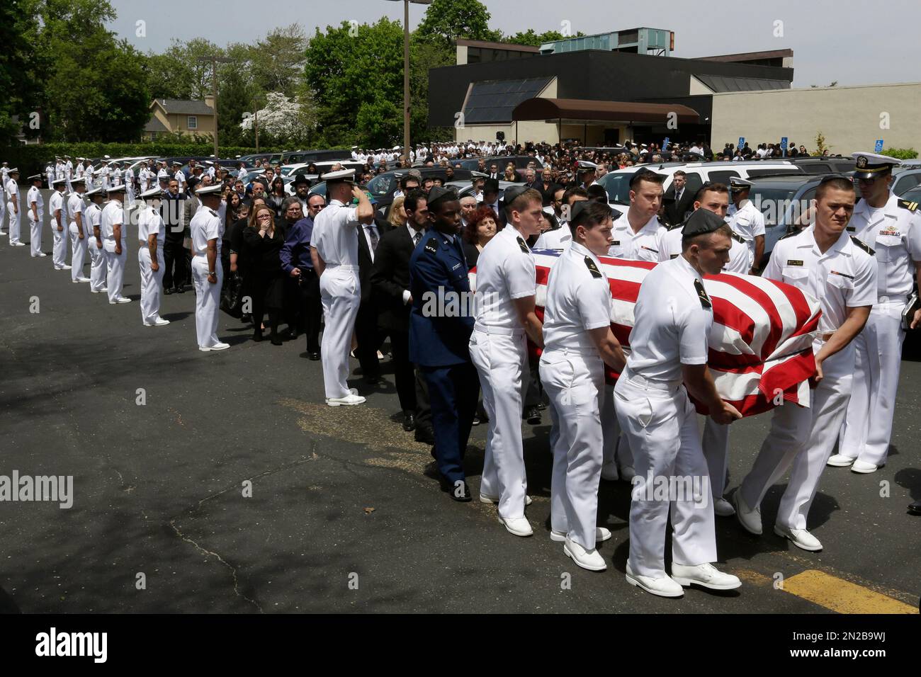 U.S. Navy midshipmen salute as the casket carrying the remains of U.S