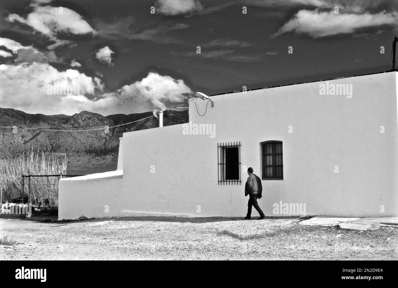 Ein Mann, der vor dem Fischerhaus spaziert und Nase, Augen und Mund bildet, Salinas, Cabo de Gata, Andalusien, Spanien Stockfoto