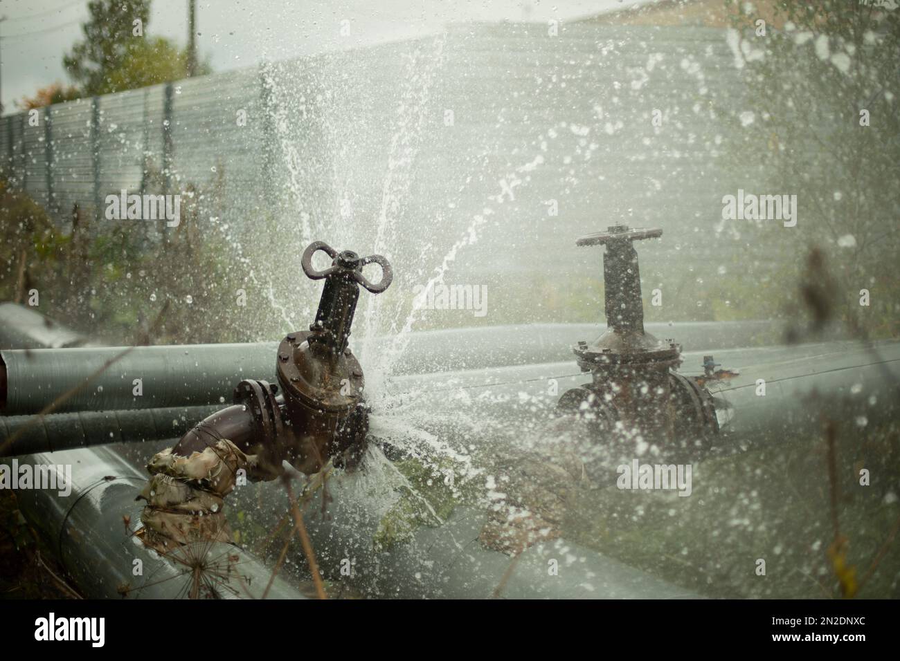 Rohrleitungsunfall. Geplatztes Rohr. Wasser strömt nach draußen. Druckverlust in der Wasserversorgung. Heißes Wasser. Stockfoto