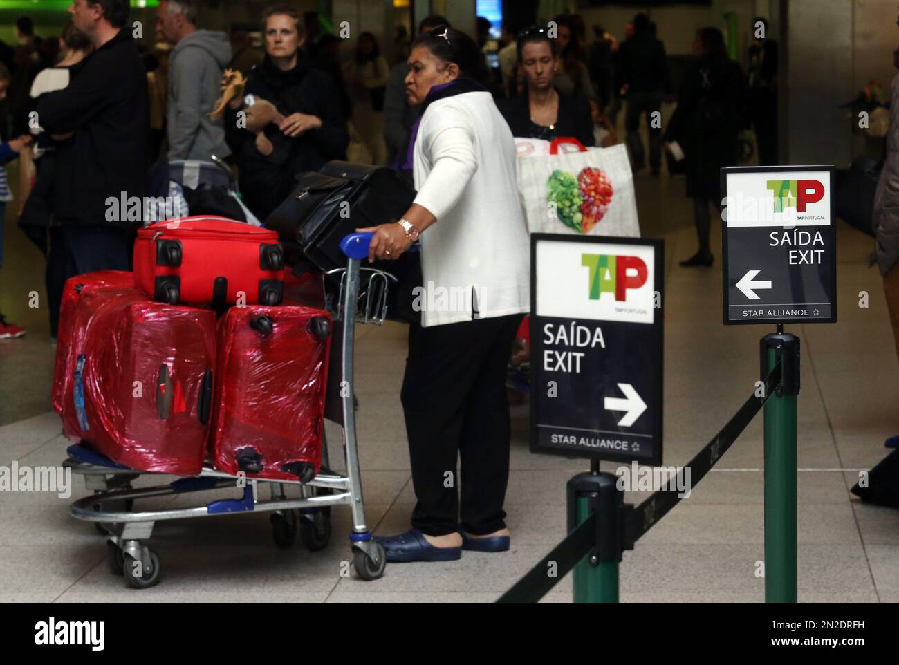 A woman waits at the check-in area of the Portuguese airline TAP's desk during the first day of a 10-day strike by TAP pilots at the Portela international airport, Friday, May 1, 2015, in Lisbon, Portugal. Pilots at Portugal's state-owned national airline have begun a 10-day strike, forcing flight cancellations as they press their demand to be given up to a 20 percent stake in the company when it is privatized later this year. (AP Photo/Francisco Seco) Stockfoto