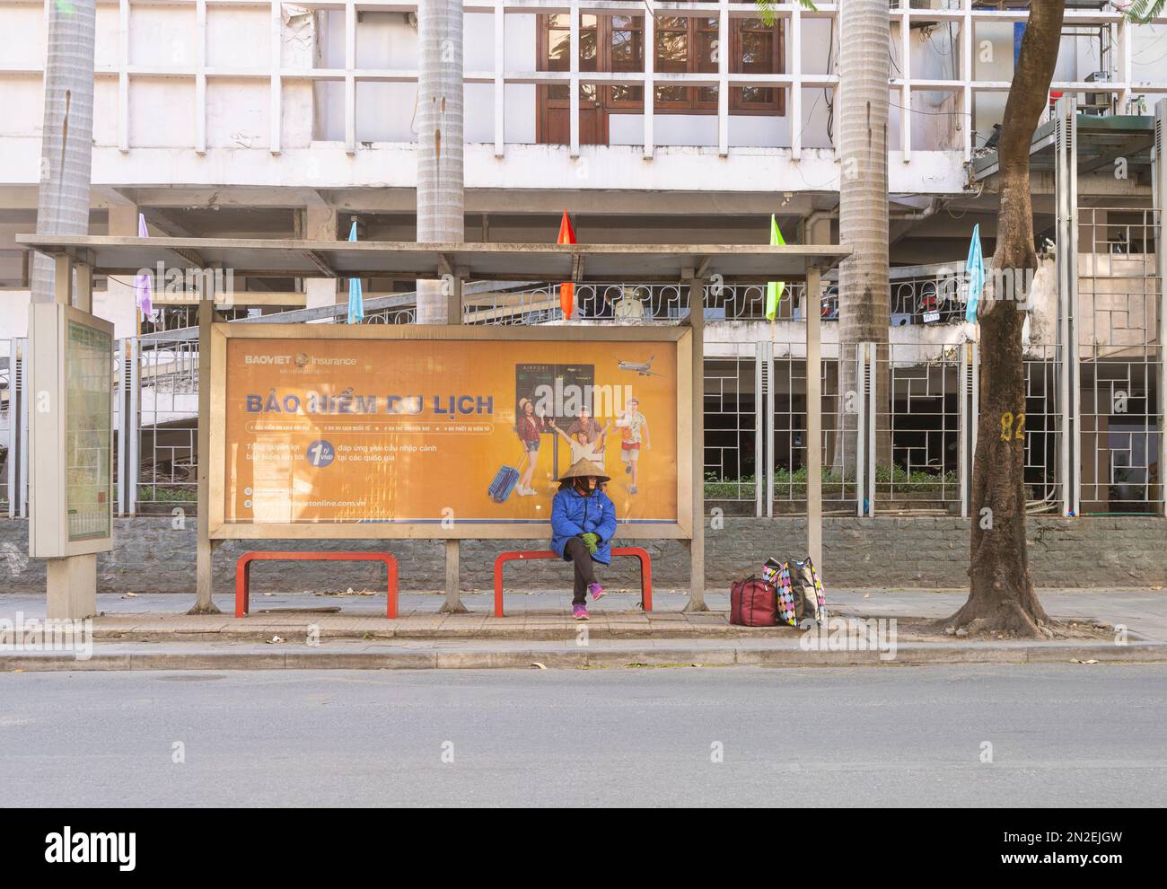 Hanoi, Vietnam, Januar 2023. Eine Frau, die im Stadtzentrum auf den Bus wartet Stockfoto