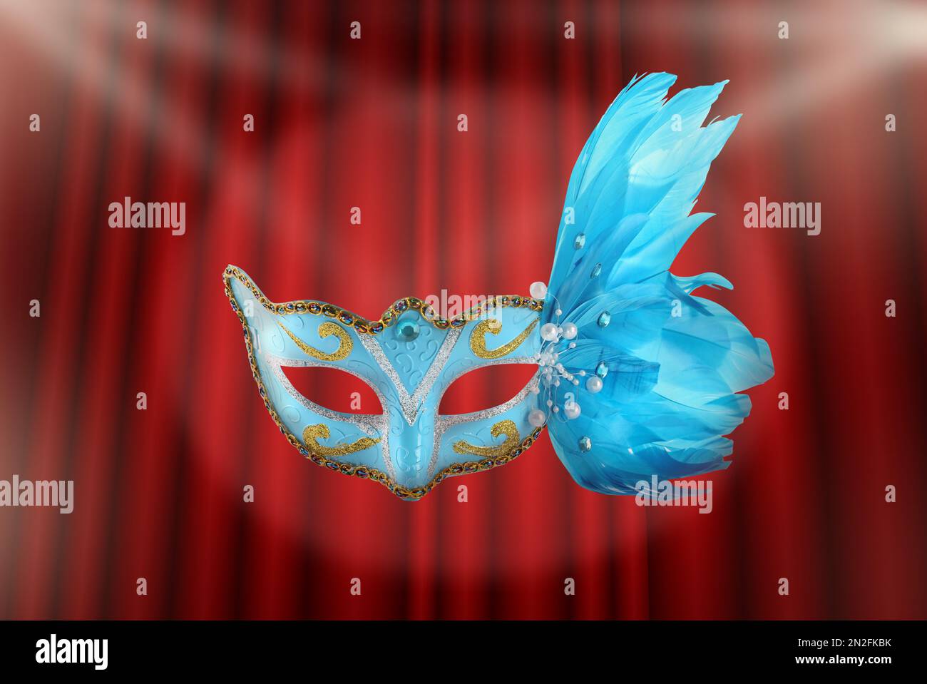 Wunderschöne Karnevalsmaske vor dem roten Vorhang Stockfoto