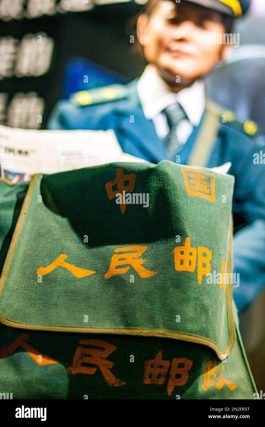 Ausstellung eines Postboten mit der Tasche mit der Aufschrift „China People’s Post Office“ im Postmuseum am Nordufer von Suzhou Cr Stockfoto