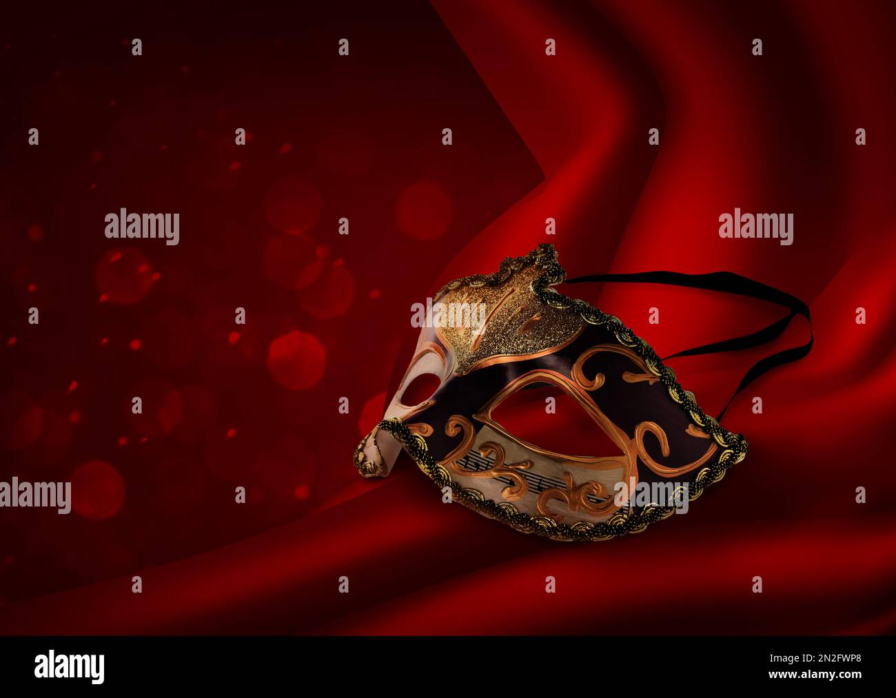 Wunderschöne Karnevalsmaske auf rotem Vorhang Stockfoto