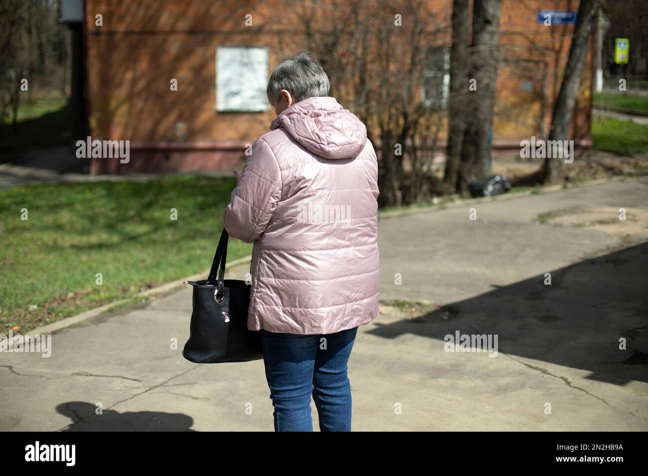 Frau in warmer Jacke im Frühling. Frau auf der Straße. Mann von hinten. Stockfoto