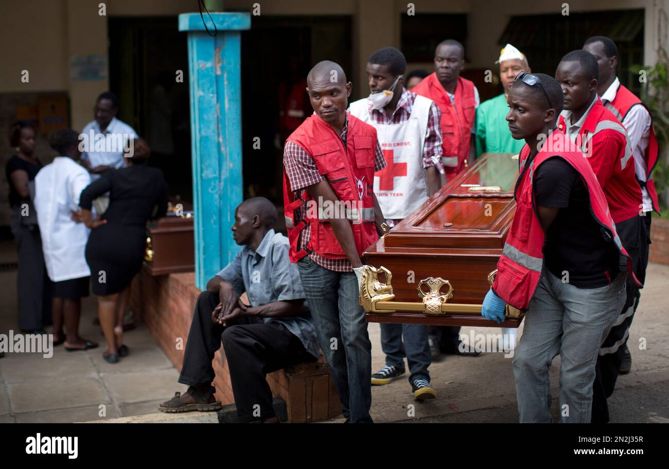 Morgue workers and Red Cross staff help to carry out the coffin of