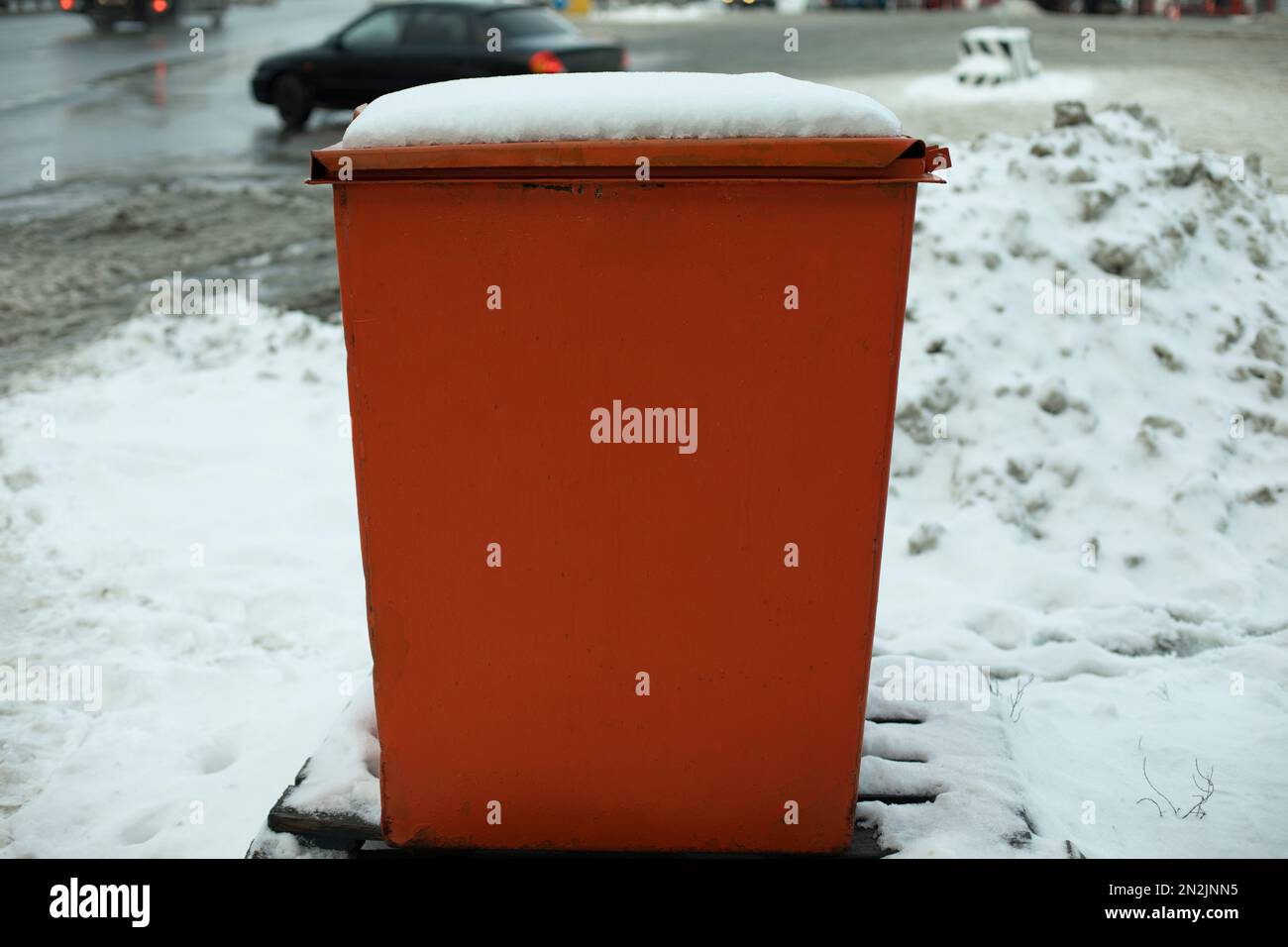 Stahltank. Müllcontainer. Platz zum Aufbewahren von Sand auf der Autobahn. Orangefarbenes Objekt im Winter auf der Straße. Angaben zur Straßeninfrastruktur. Stockfoto