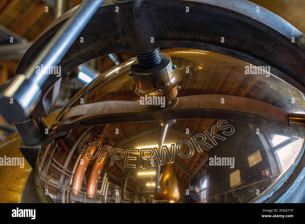 Die Männertür eines Kupfertopfs diente noch zur Destillation des NC'Nean Organic Single Malt Whisky an der Westküste Schottlands. Stockfoto