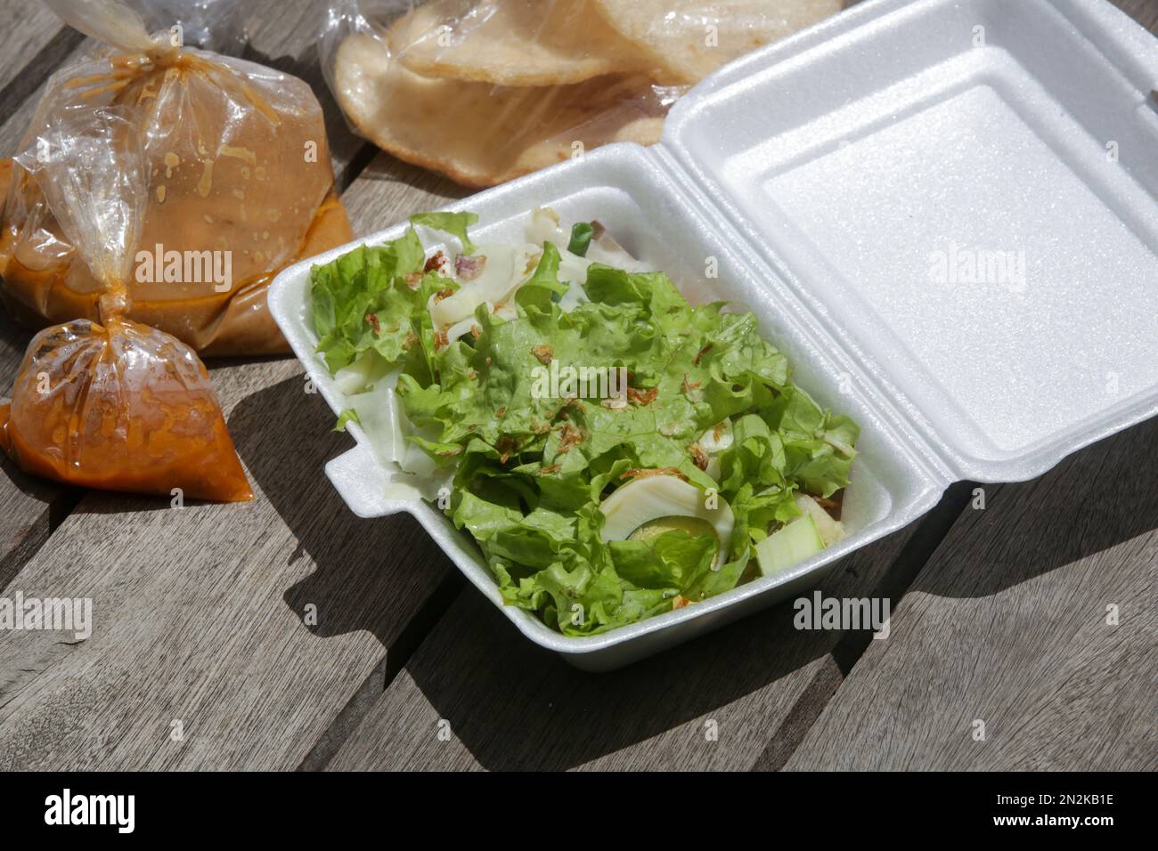 Indonesischer Salat mit Salat und gedämpftem Gemüse, serviert mit einem Erdnusssoße-Dressing, Paket zum Mitnehmen Stockfoto