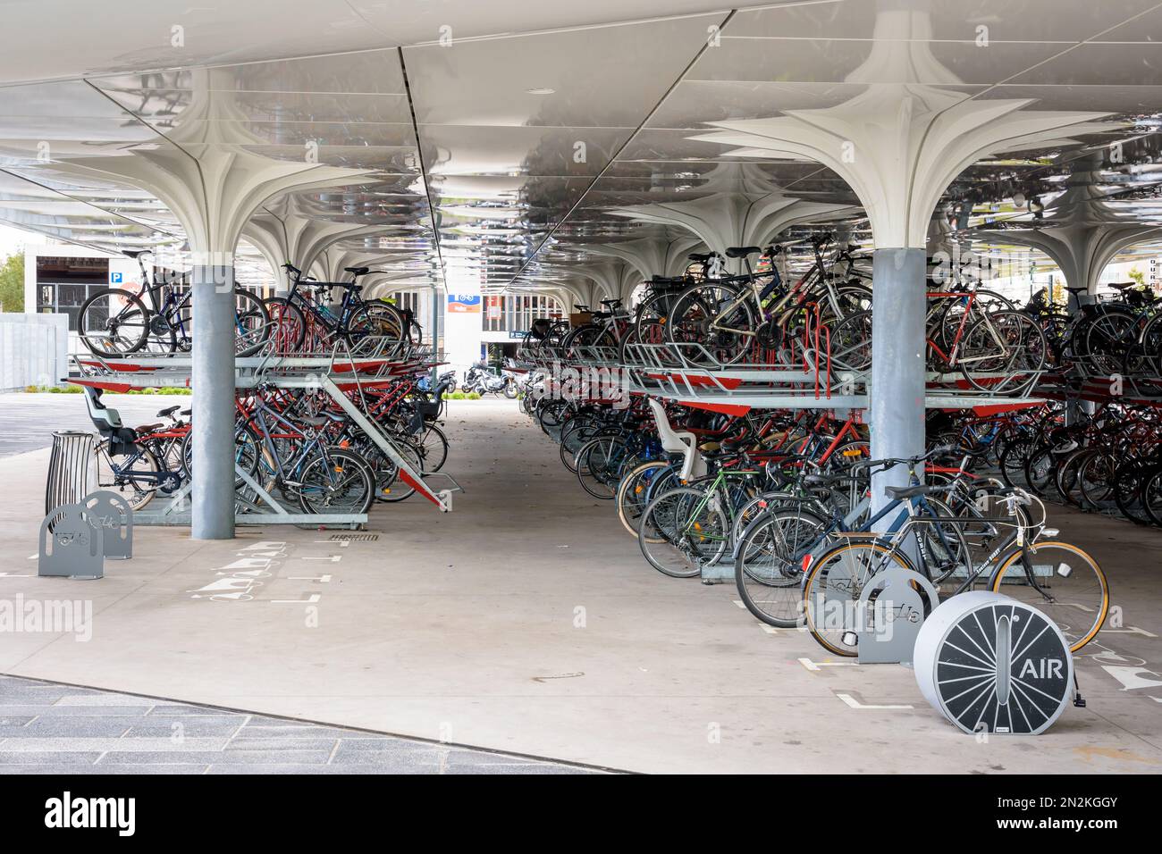 Tagsüber stehen Hunderte von Fahrrädern auf einem überdachten Doppelstockparkplatz vor dem Bahnhof in Nantes, Frankreich, bereit. Stockfoto