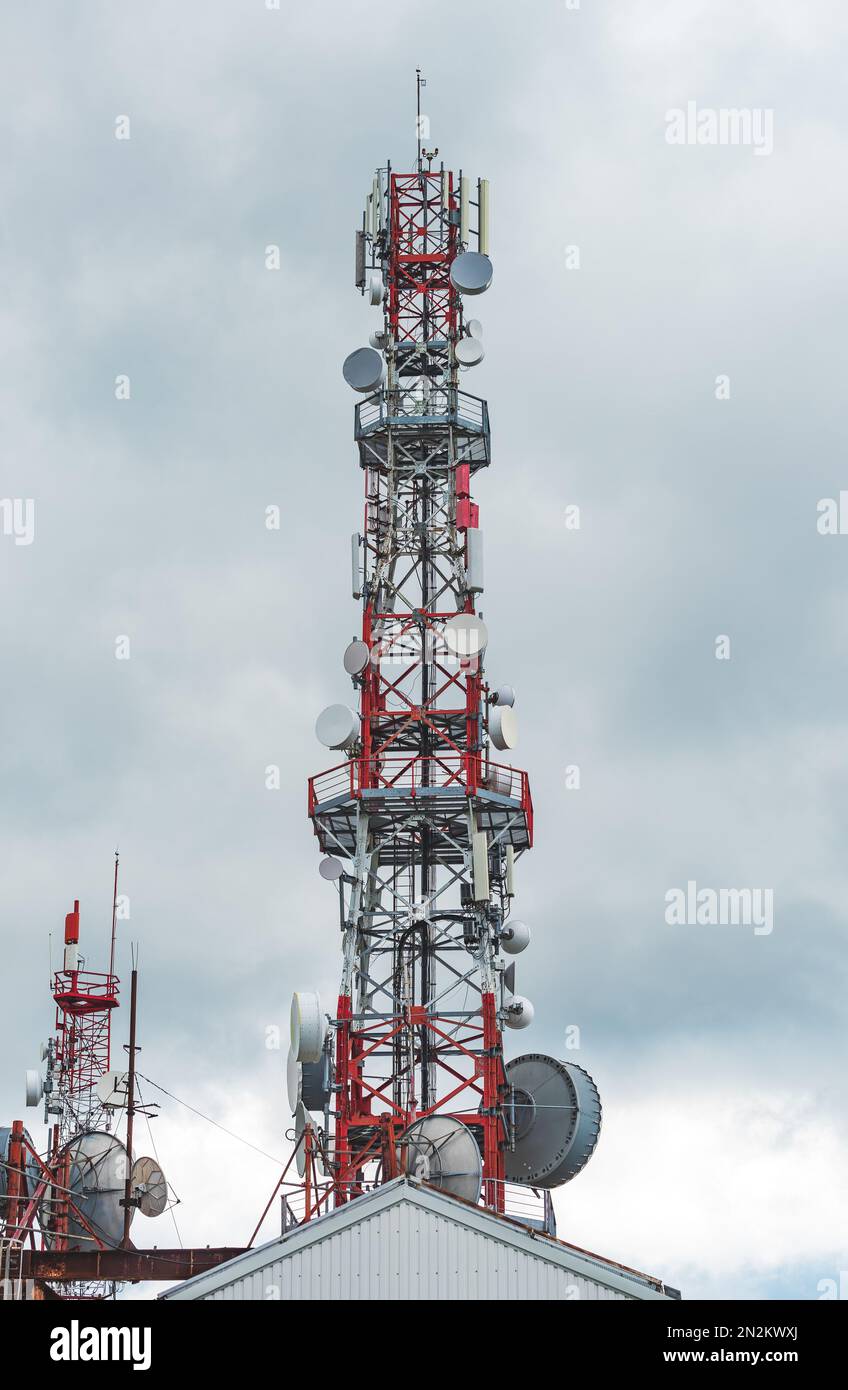 Telekommunikationsturm und Mobilfunksignalrepeater auf der Bergspitze am bewölkten Tag Stockfoto