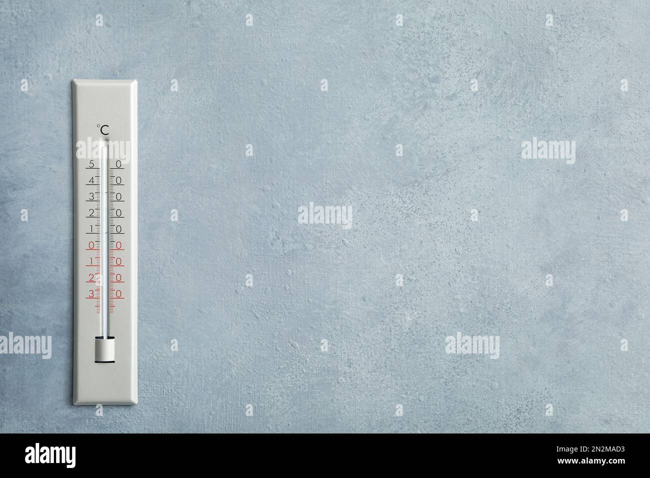 Wetterthermometer an grauer Wand. Platz für Text Stockfoto