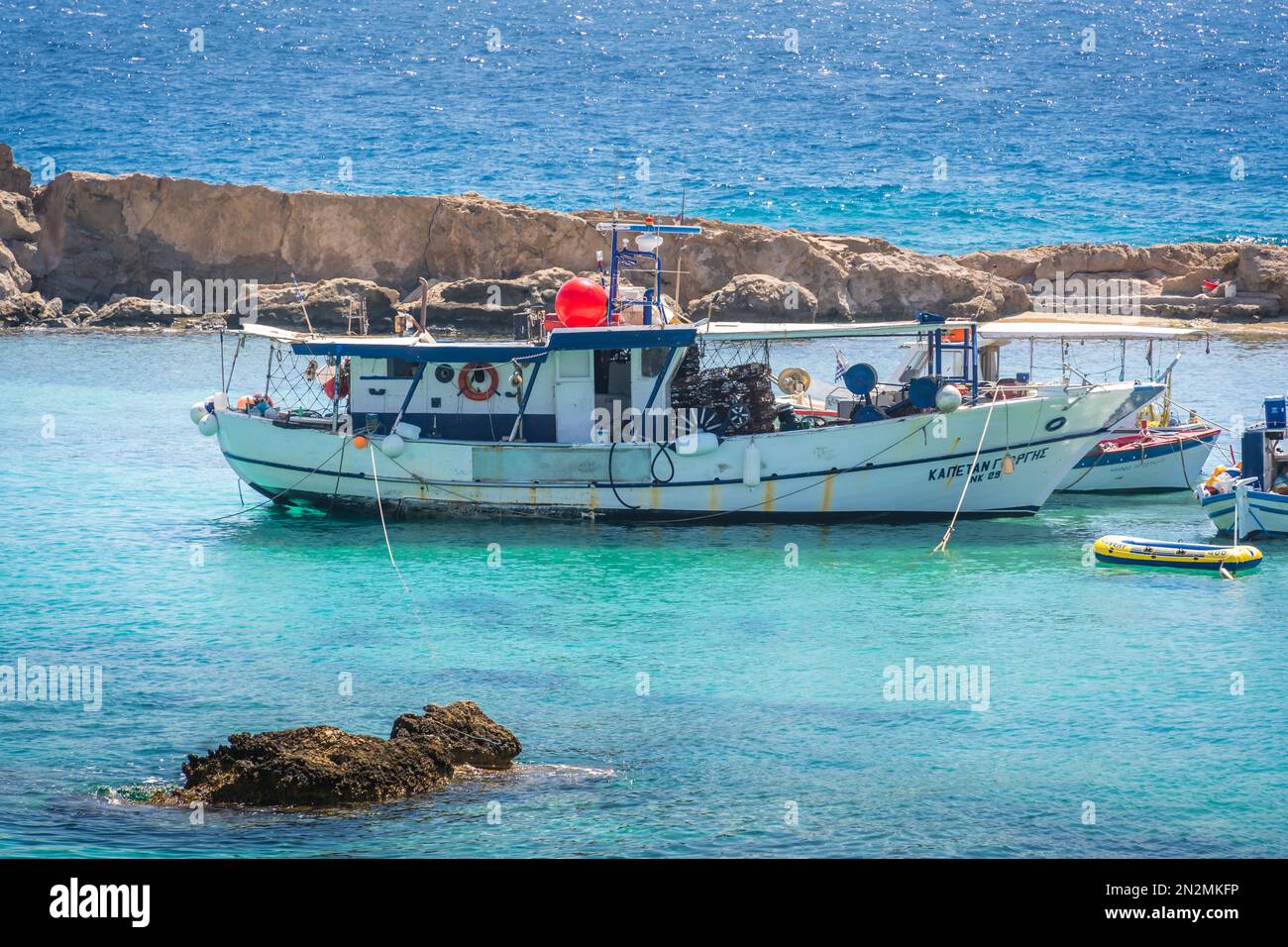 Lefkos Beach, Karpathos, Griechenland - August 2022 : kleines Boot in einer wunderschönen Bucht im Sommer Stockfoto