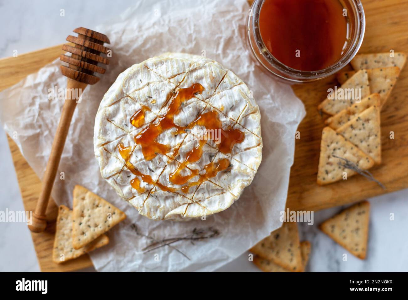 camembert weicher französischer Käse serviert mit flüssigem Honig und Crackern, Draufsicht Stockfoto