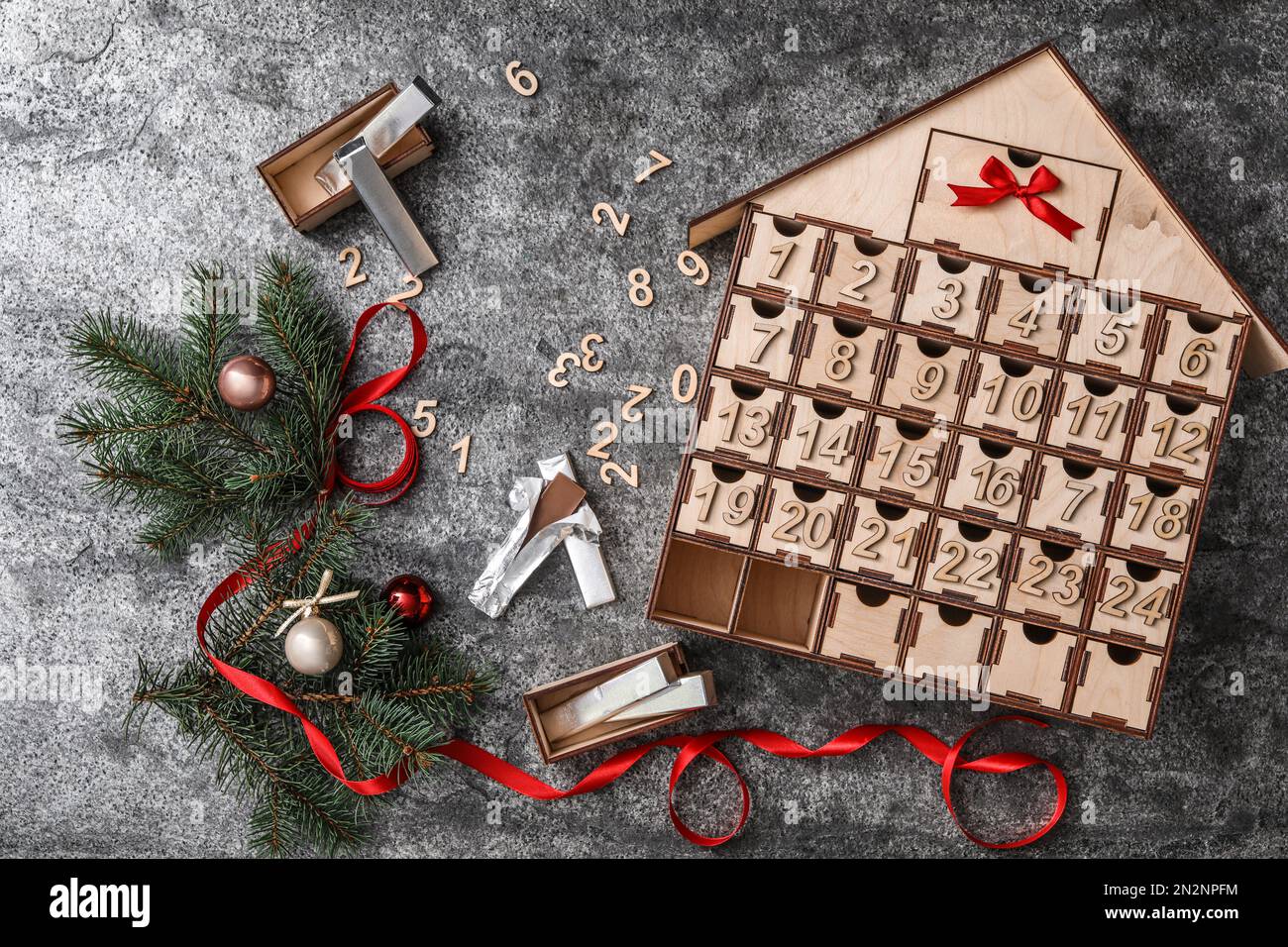 Flache Lagezusammensetzung mit hausgemachtem Adventskalender und Weihnachtsdekor auf grauem Hintergrund Stockfoto