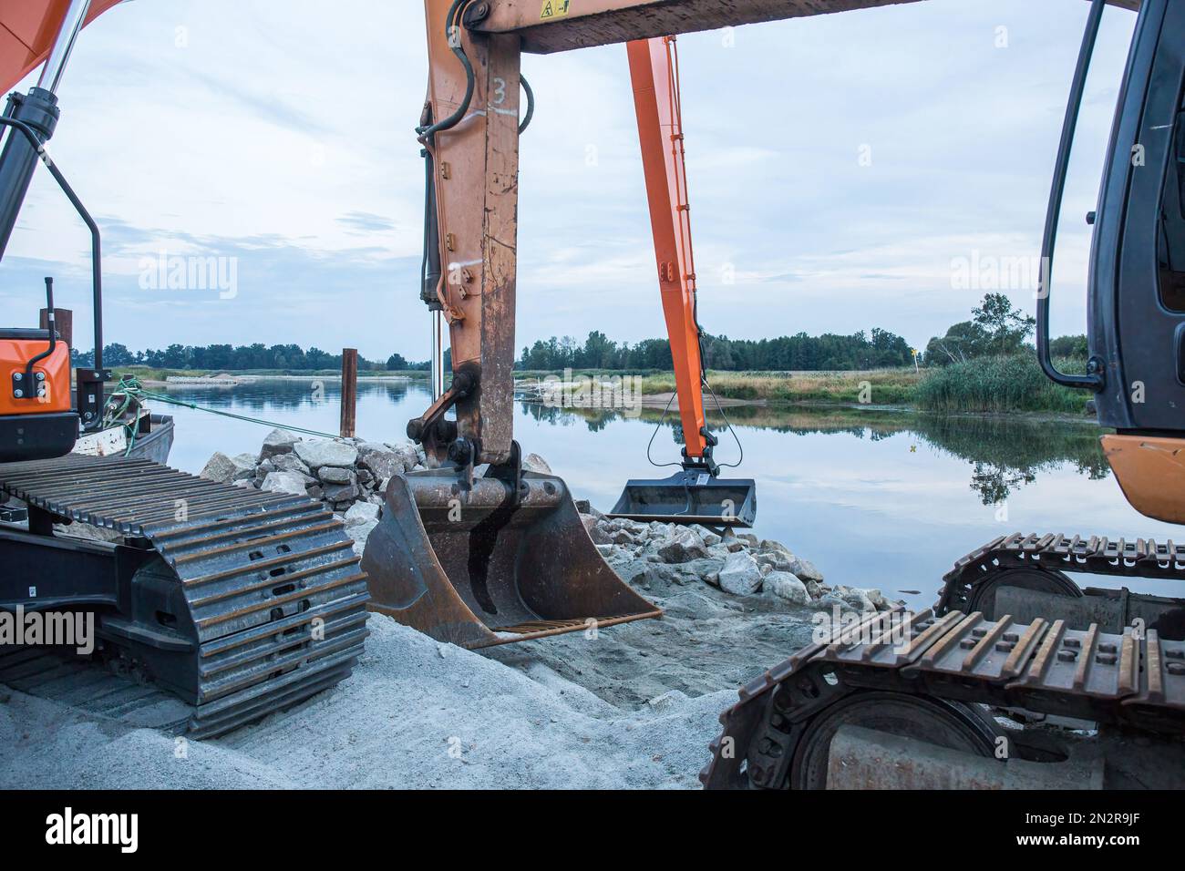 Baumaschinen, die Regelarbeiten am Fluss Odra durchführen, um ihn an die Wasserstraße der Klasse III im Dorf Brody anzupassen. Die Odra ist eine wichtige Kommunikationsroute, sie ist Teil der Wasserstraße E30, die die Ostsee mit der Donau in Bratislava verbindet. Die Wasserstraße E30 in Polen umfasst die Odra von der Grenze zur Tschechischen Republik bis Swinoujscie; Wo sich das LNG-Terminal Swinoujscie befindet.WWF Deutschland und Experten des IGB Leibniz-Instituts für Süßwasserökologie und Binnenfischerei fordern die Einstellung der Arbeiten zur Erweiterung des oder-Flussbetts und der Re Stockfoto