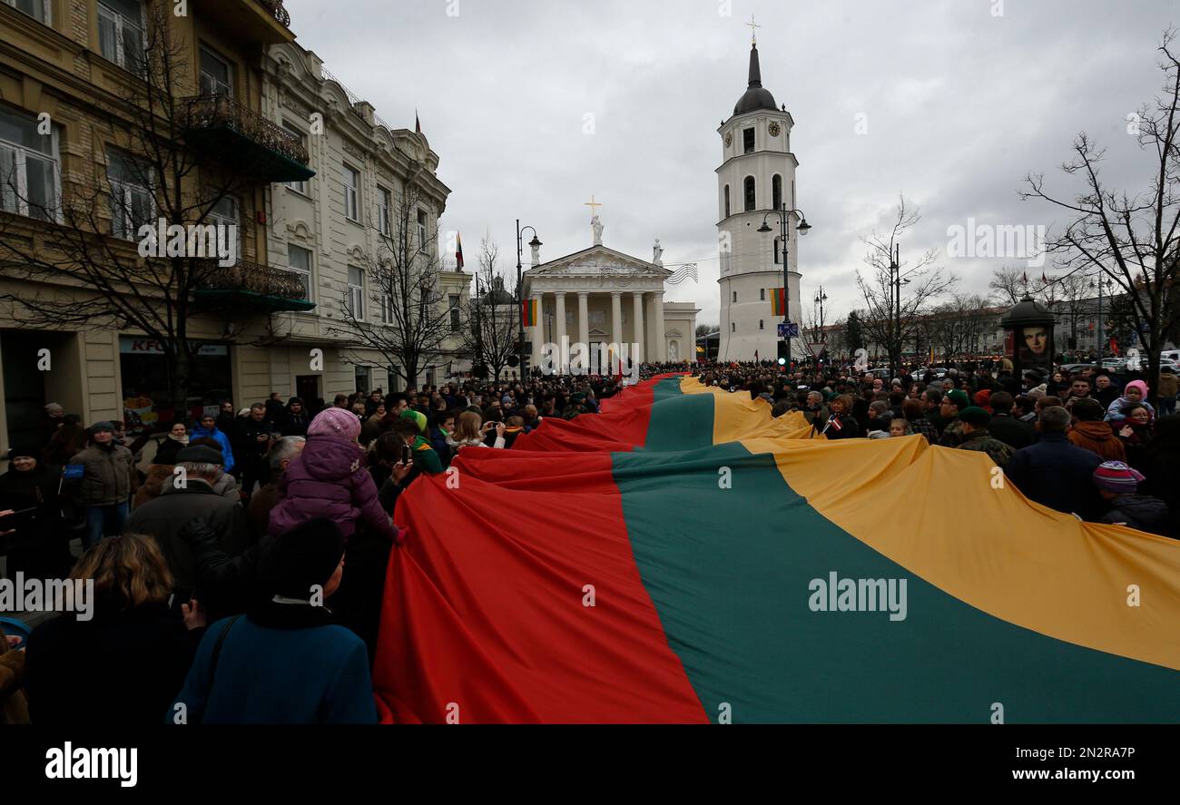 People carry a giant Lithuanian flag during a celebration of Lithuania's independence in Vilnius, Lithuania, Wednesday, March 11, 2015. Lithuania celebrated the 25th anniversary of its declaration of independence from the Soviet Union on Wednesday, recalling the seminal events that set the Baltic nation on a path to freedom and helped lead to the collapse of the U.S.S.R. (AP Photo/Mindaugas Kulbis) Stockfoto