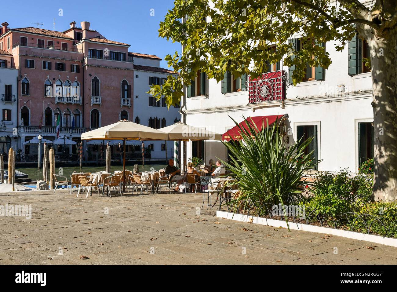 Touristen in einem Straßencafé mit Blick auf den Canale Granale Grande im Campo San Simeone Grande, einem kleinen Platz im Sestiere von Santa Croce, Venedig, Italien Stockfoto