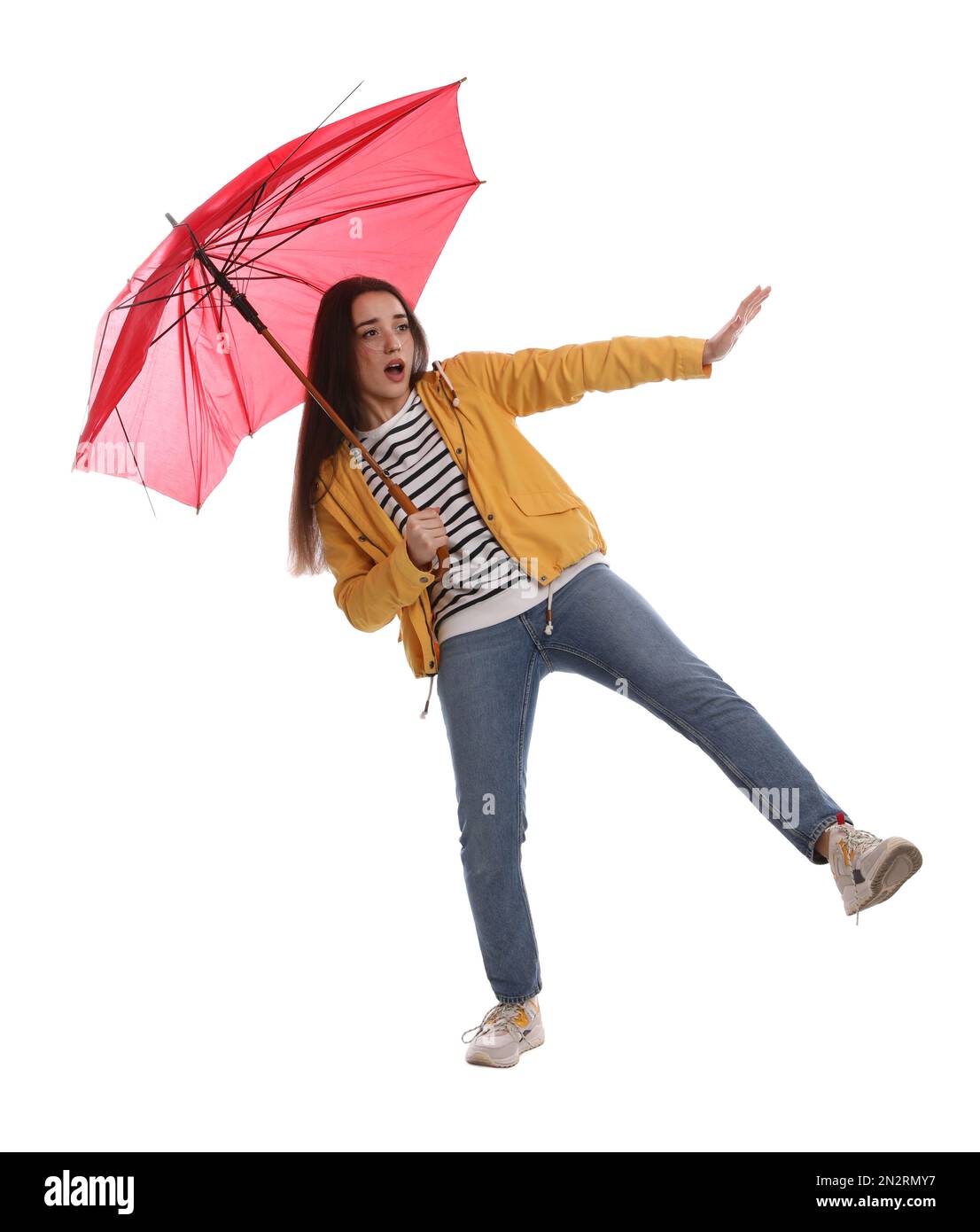 Emotionale Frau mit Regenschirm, die in Windböen auf weißem Hintergrund gefangen war Stockfoto