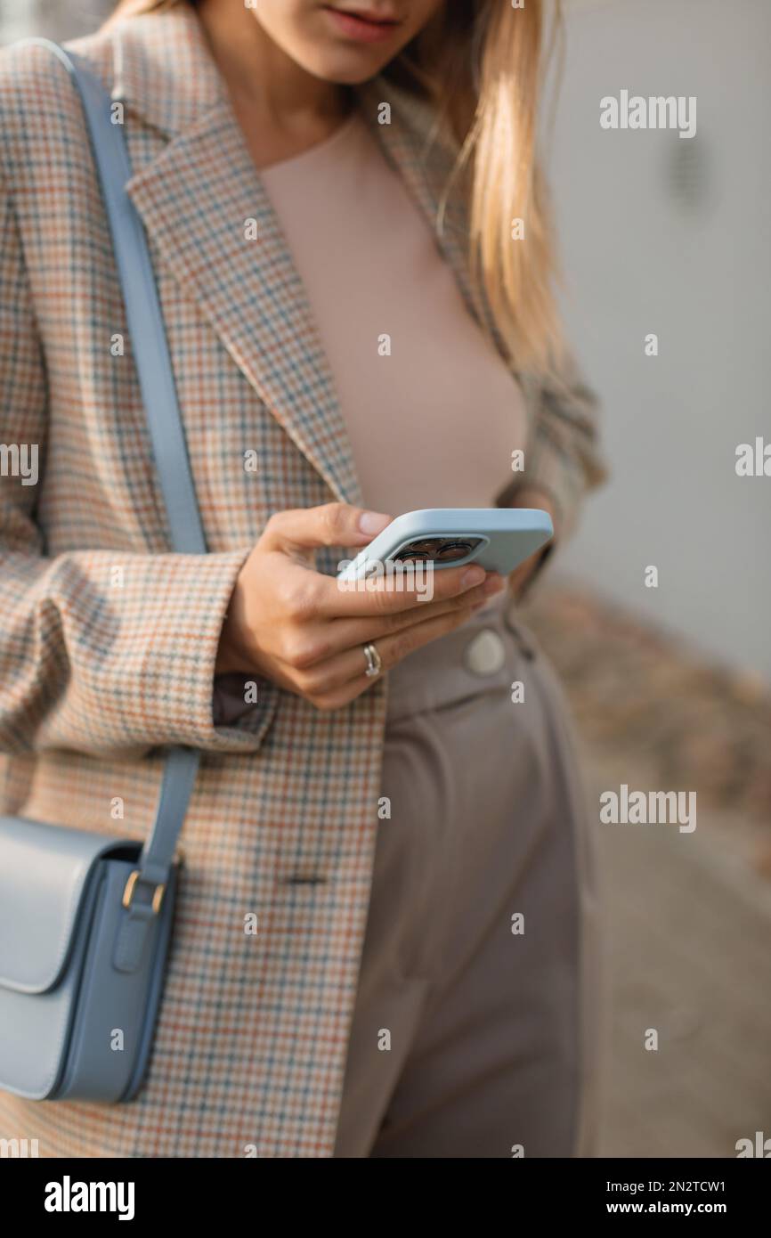 Nahaufnahme einer stilvollen Geschäftsfrau, die auf der Straße mit ihrem Mobiltelefon in Belarus stand Stockfoto