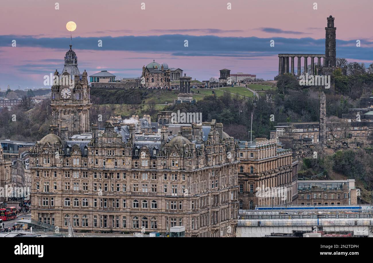 Blick auf den Uhrenturm des Balmoral Hotels und Calton Hill mit Vollmond in der Dämmerung, Edinburgh, Schottland, Großbritannien Stockfoto