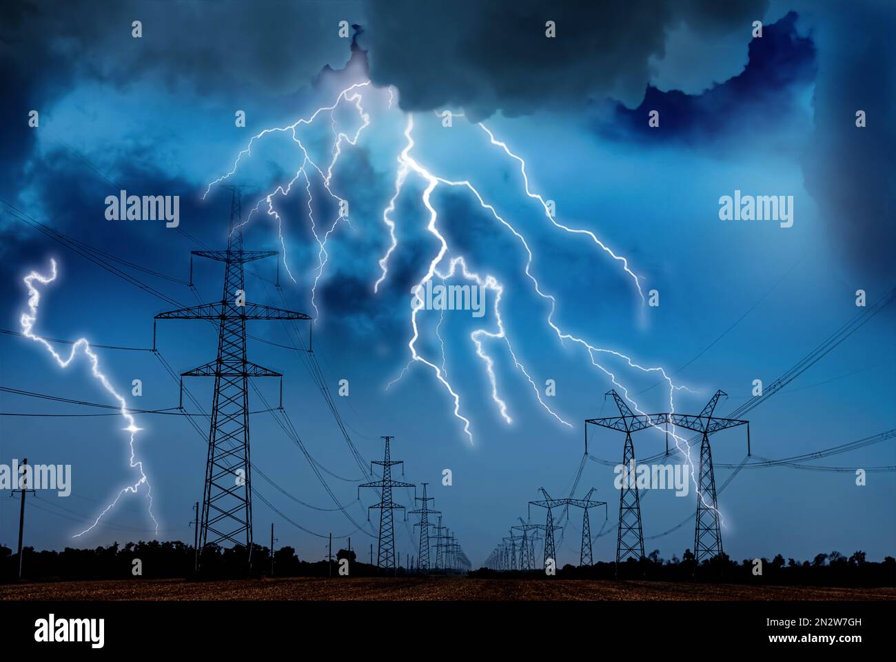 Malerischer Gewitter über dem Feld mit Hochspannungsmasten Stockfoto