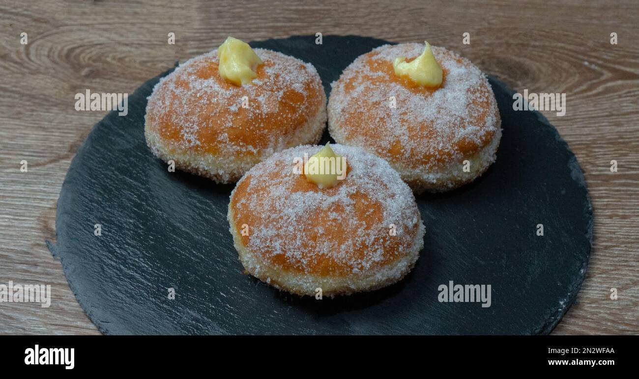 Hausgemachte gebratene Donuts gefüllt mit Vanille und gewürzt mit einem Schleier Zucker Stockfoto