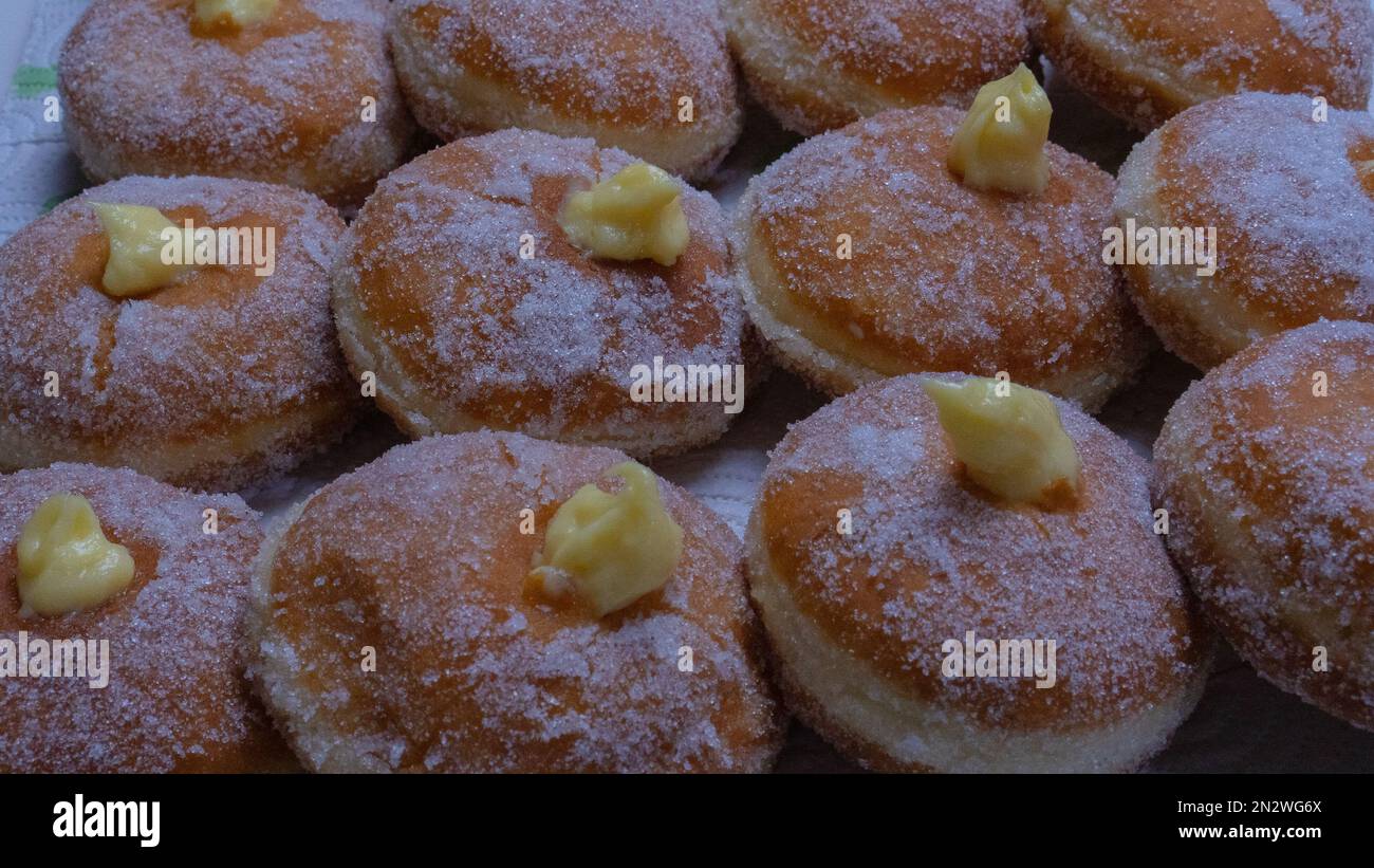 Hausgemachte gebratene Donuts gefüllt mit Vanille und gewürzt mit einem Schleier Zucker Stockfoto