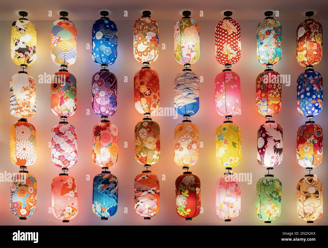 Verschiedene Arten von bunten japanischen Laternen, die an der Wand hängen. Stockfoto