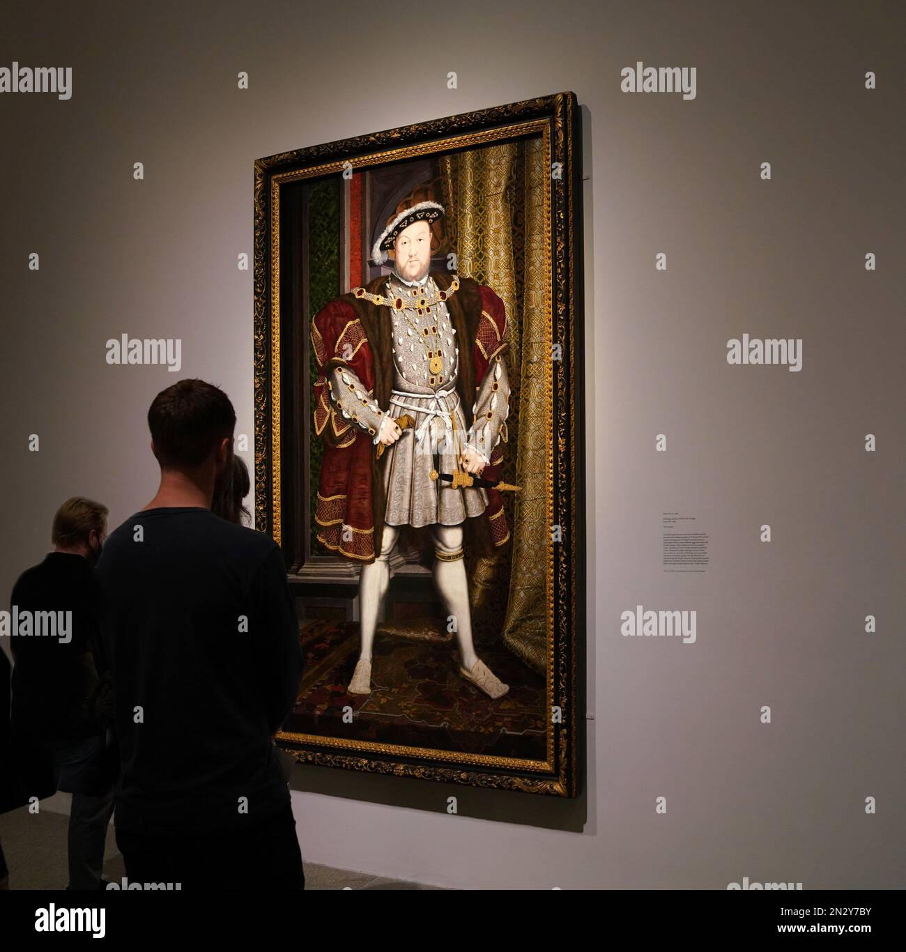 New York, NY - Oktober 2022: Besucher der Met's Tudor Gallery bewundern ein Porträt von König Heinrich VIII., von Hans Holbein, ca. 1540. Stockfoto