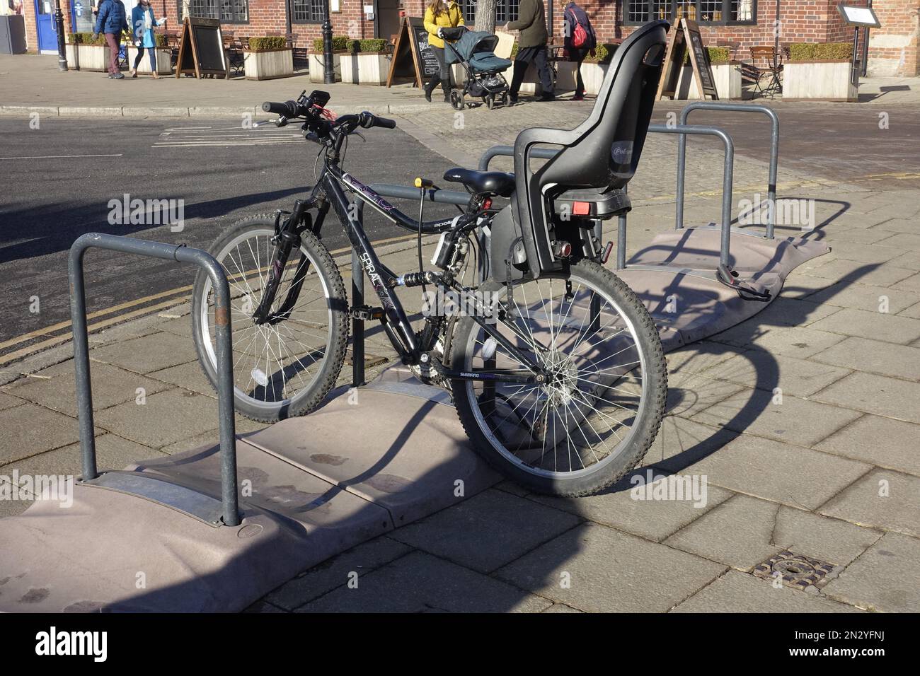 Modernes Fahrrad mit Kindersitz im Fahrradständer Stratford on Avon UK Stockfoto