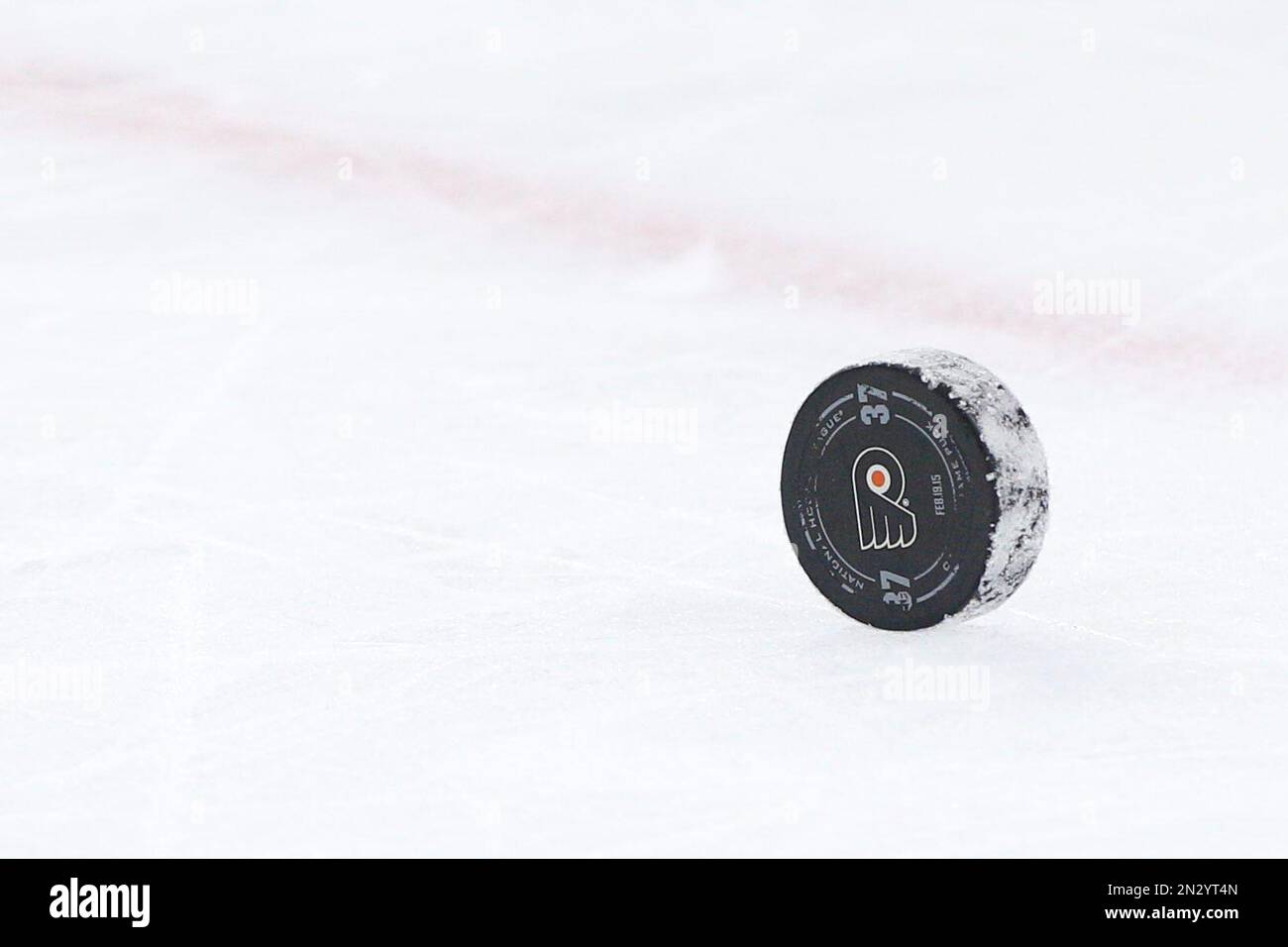 The puck with the #37 on it for former Philadelphia Flyers Eric Desjardins, who was inducted in the Flyers Hall of Fame, during the third period of an NHL hockey game, Thursday, Feb. 19, 2015, in Philadelphia. Sabres won 3-2 by shootout. (AP Photo/Chris Szagola) Stockfoto