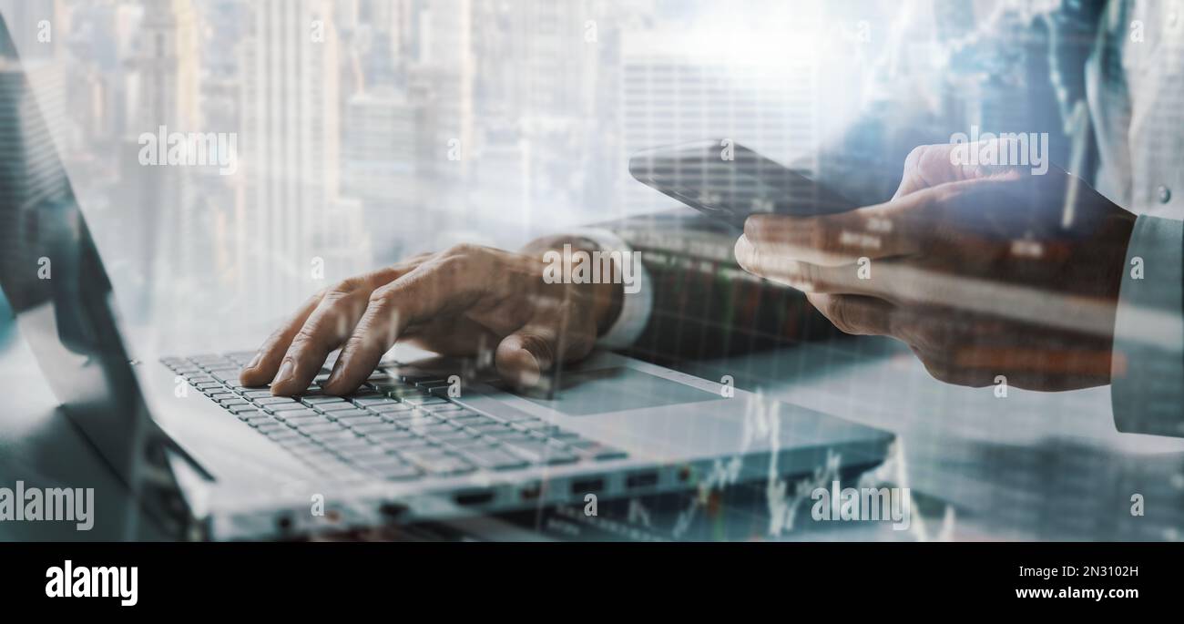 Hintergrund für Unternehmensfinanzierung und Finanztechnologie. Geschäftsmann, der an einem Laptop arbeitet und ein Smartphone in einem modernen Büro verwendet. Banner Stockfoto