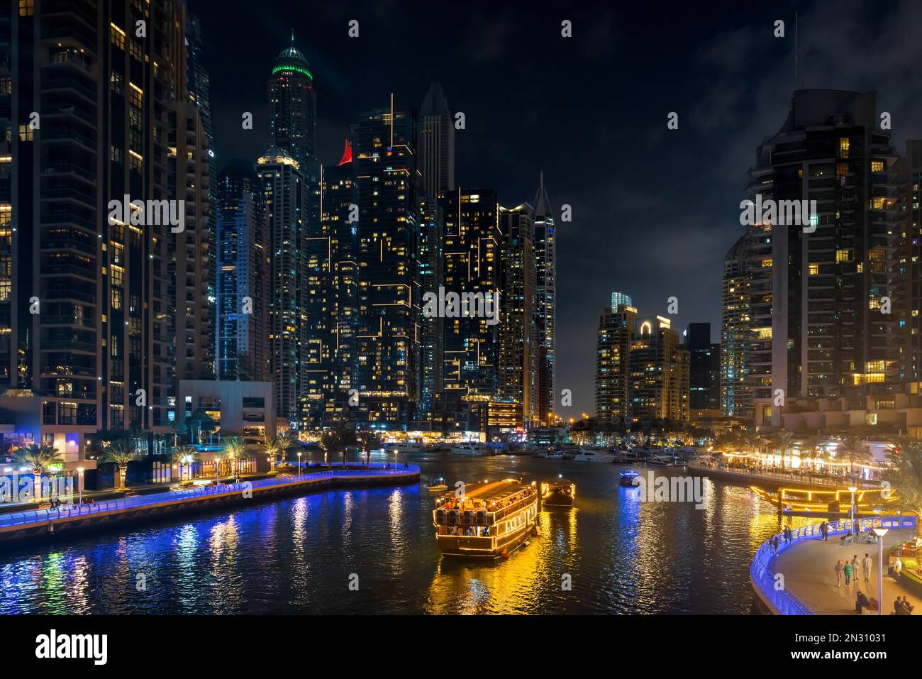 Dubai Marina Stadtbild bei Nacht mit beleuchteten Wolkenkratzern und Booten im Kanal. VAE Stockfoto