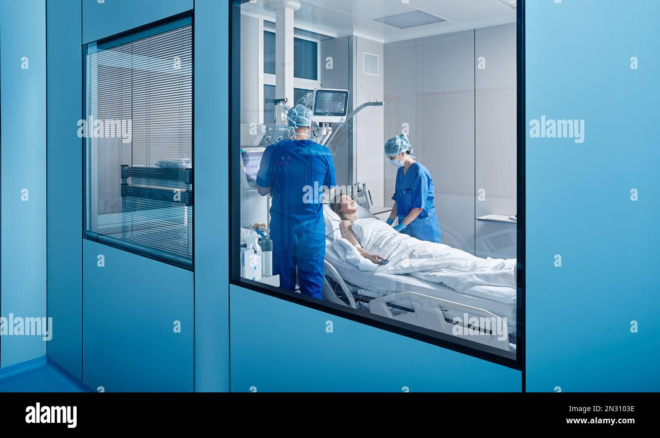 Arzt und Krankenschwester, die Patientin auf der Intensivstation betreuen und ihre Gesundheit überprüfen. INTENSIVSTATION Stockfoto