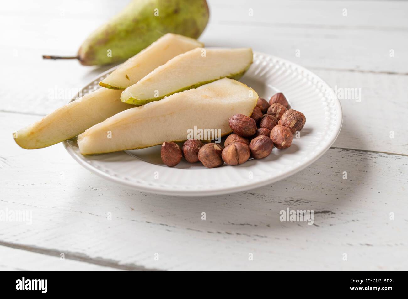 Gesunder Nachmittagssnack mit frischen Birnen und Haselnüssen Stockfoto