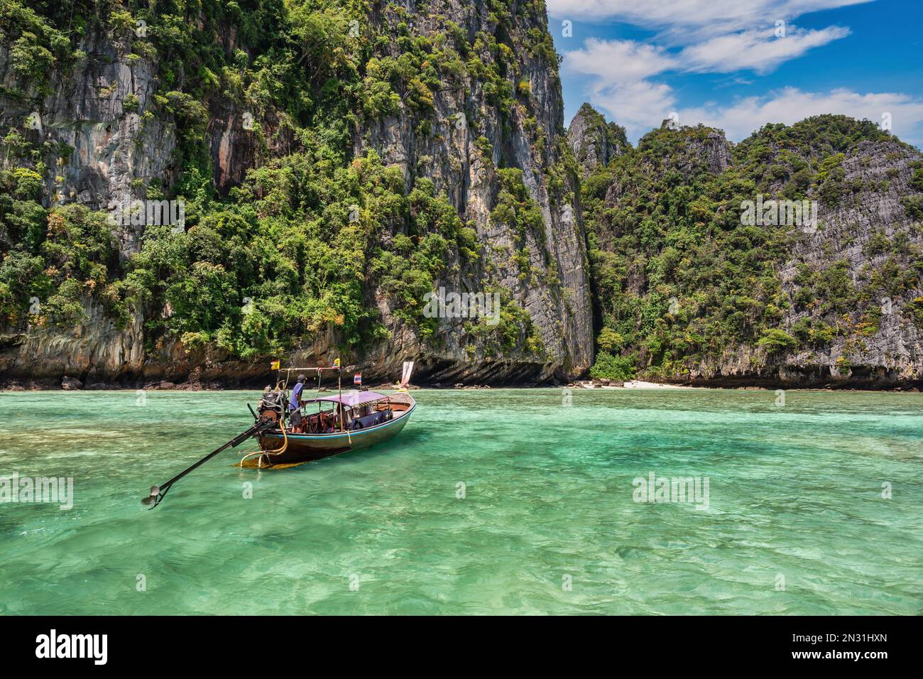 Blick auf die tropischen Inseln mit einem Boot mit langem Schwanz, blauem Meerwasser auf der Pileh Lagune der Phi Phi Inseln, Krabi Thailand Naturlandschaft Stockfoto