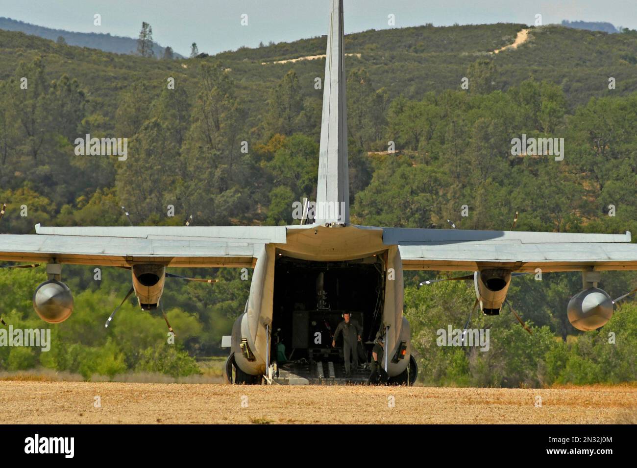 C-130 Hercules öffnet Frachtraum mit 13. Marine Expeditionary Unit Crewmen auf einer unbefestigten Landebahn während der militärischen Übung, Fort Hunter Liggett, Kalifornien. Stockfoto