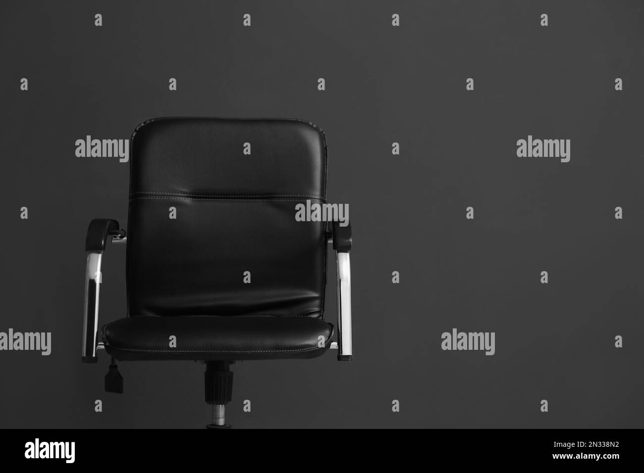 Komfortabler Bürostuhl auf schwarzem Hintergrund. Platz für Text Stockfoto