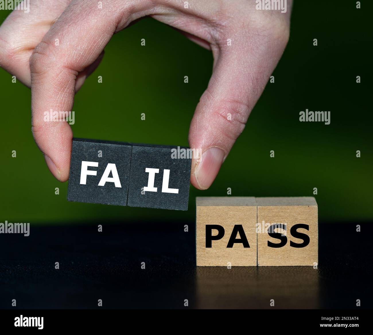 Mit der Hand werden Würfel mit dem Wort 'FAIL' anstelle von Würfel mit dem Wort 'Pass' ausgewählt. Symbol für nicht bestandenen Test. Stockfoto